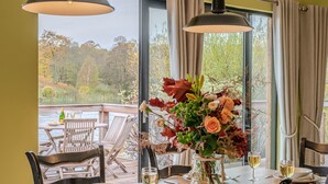 A dining table with a vase of flowers, wine glasses, and a bottle of champagne. - Louis -  a lodge that sleeps 6 guests  in 3 bedrooms (Richmond)