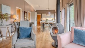 Una sala moderna con chimenea, asientos cómodos y vistas a la cocina.