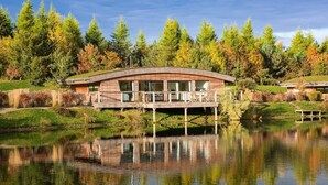 A modern house with a wooden deck and a pond in front. - Lulu -  a lodge that sleeps 6 guests  in 3 bedrooms (Near Richmond)