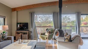 A spacious living area with a television, seating, and a view of the outdoors.