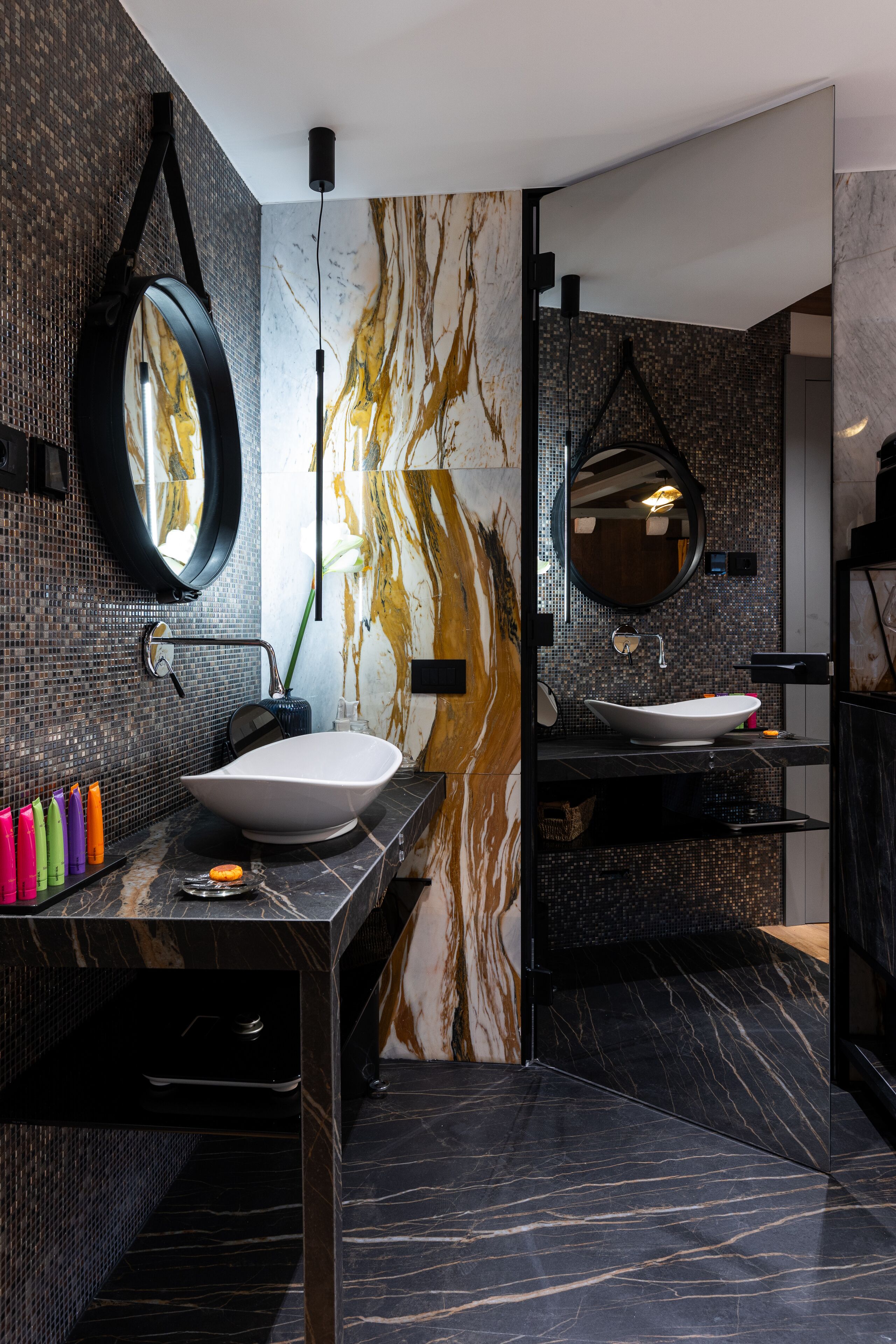 Un bagno moderno con un grande specchio, un lavabo a incasso e uno schienale in marmo.
