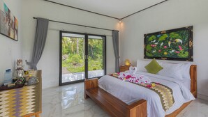 A bedroom with a bed, a window, a painting, and a bedside table. - Radjes Bungalow Nusa Penida (Penida Island)