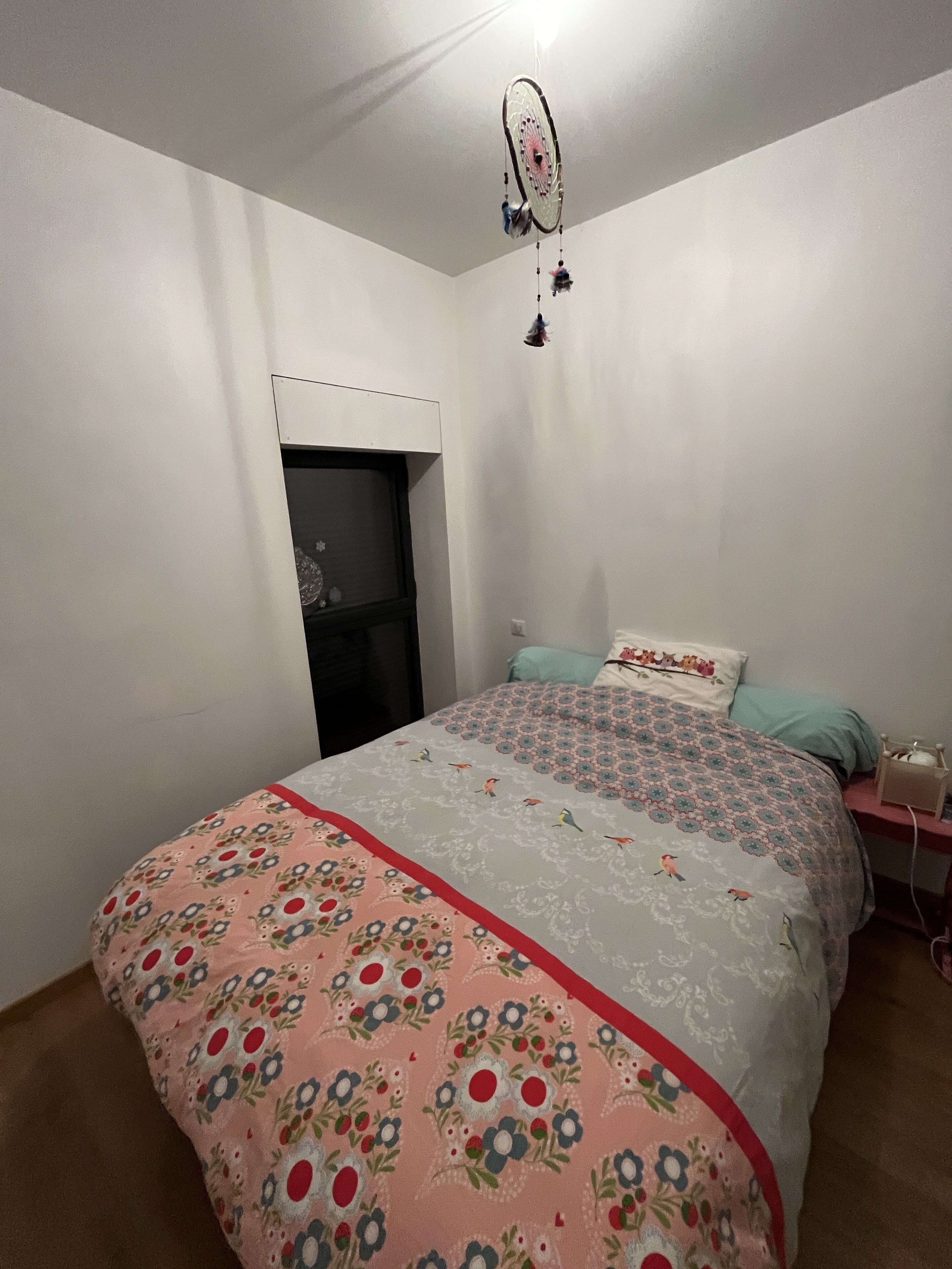 A bedroom with a bed, a nightstand, a dresser, and a wardrobe.