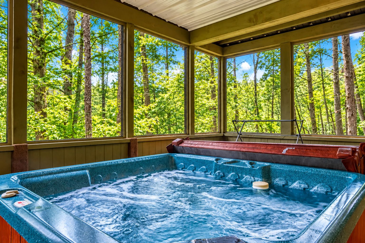 Un jacuzzi con vistas a un bosque a través de amplios ventanales.