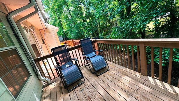 A wooden deck with two blue chairs and a wooden railing. - Cozy 2BR Home Near Atlanta, Six Flags and Trails (Mableton)