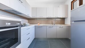 Una cocina moderna con horno empotrado, lavamanos y refrigerador.