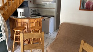 Una cocina con taburetes de madera, una cafetera y una estufa.