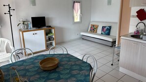 Un espace de vie compact comprenant un coin repas, une kitchenette et un coin salon.