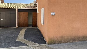 Un edificio con puerta numerada, puerta de garaje y tejado de tejas.