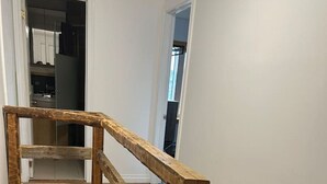 En trätrappa med ett ledstång som leder upp till en liten plattform.