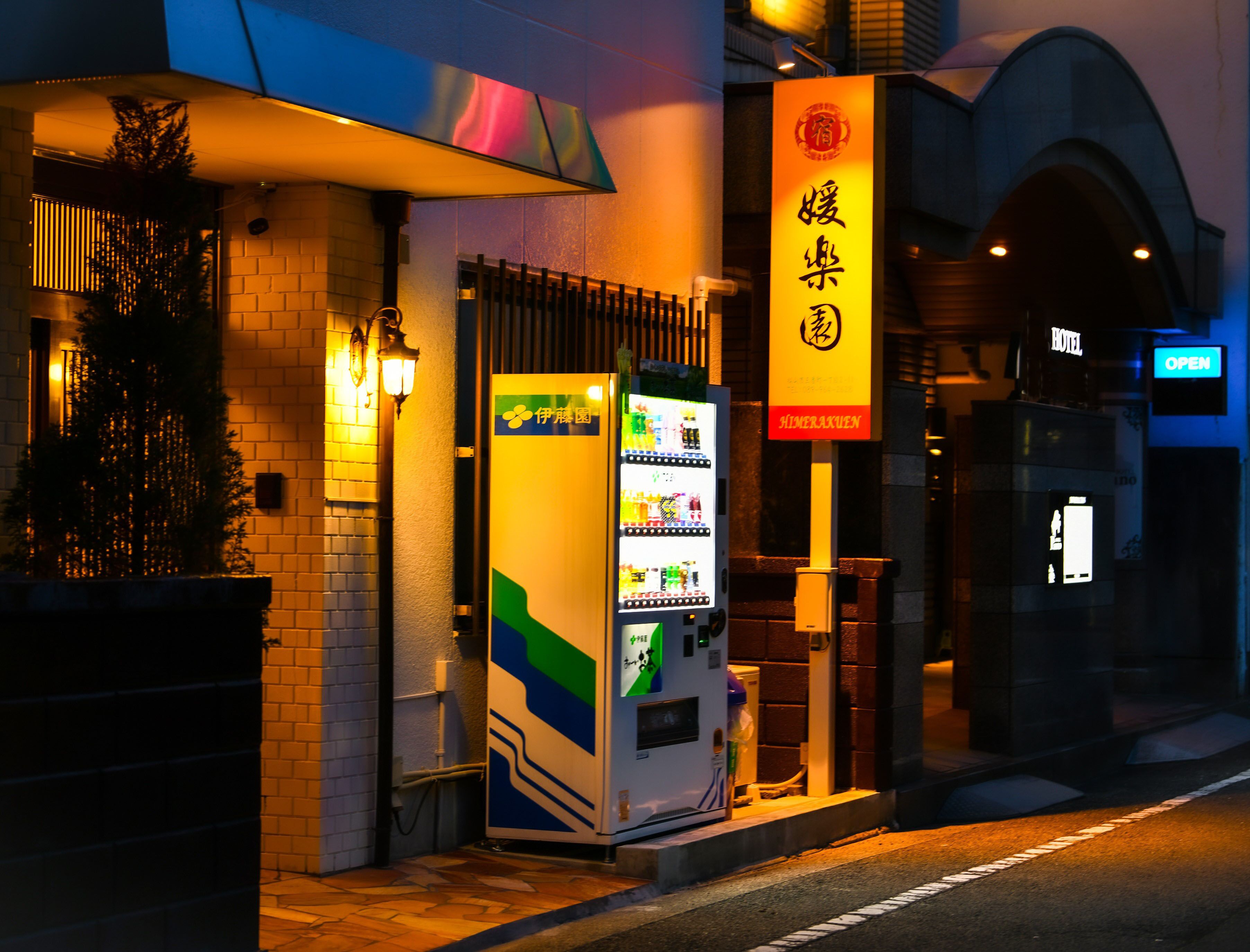 A hotel entrance with a vending machine and a sign in a foreign language.