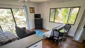 A room with a bed, a desk, a chair, a television, and a refrigerator. - The Treehouse (Amanzimtoti)