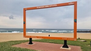 A sign at Toti Main Beach in Durban, South Africa, with a beach and ocean in the background. - The Treehouse (Amanzimtoti)