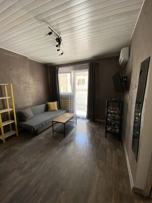 Cozy living space with a sofa, coffee table, and shelving unit.