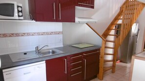 A kitchen with a dishwasher, sink, and wooden staircase. - HOLIDAYLAND T2 MEZZANINE 314 6 beds NARBONNE PLAGE (NARBONNE PLAGE)