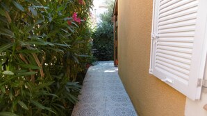A narrow pathway with patterned tiles leading to a building with a beige wall and white shutters. - HOLIDAYLAND T2 MEZZANINE 314 6 beds NARBONNE PLAGE (NARBONNE PLAGE)