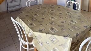 Une cuisine compacte dotée de meubles en bois, d’un four à micro-ondes, d’un évier et d’une table à manger avec des chaises.
