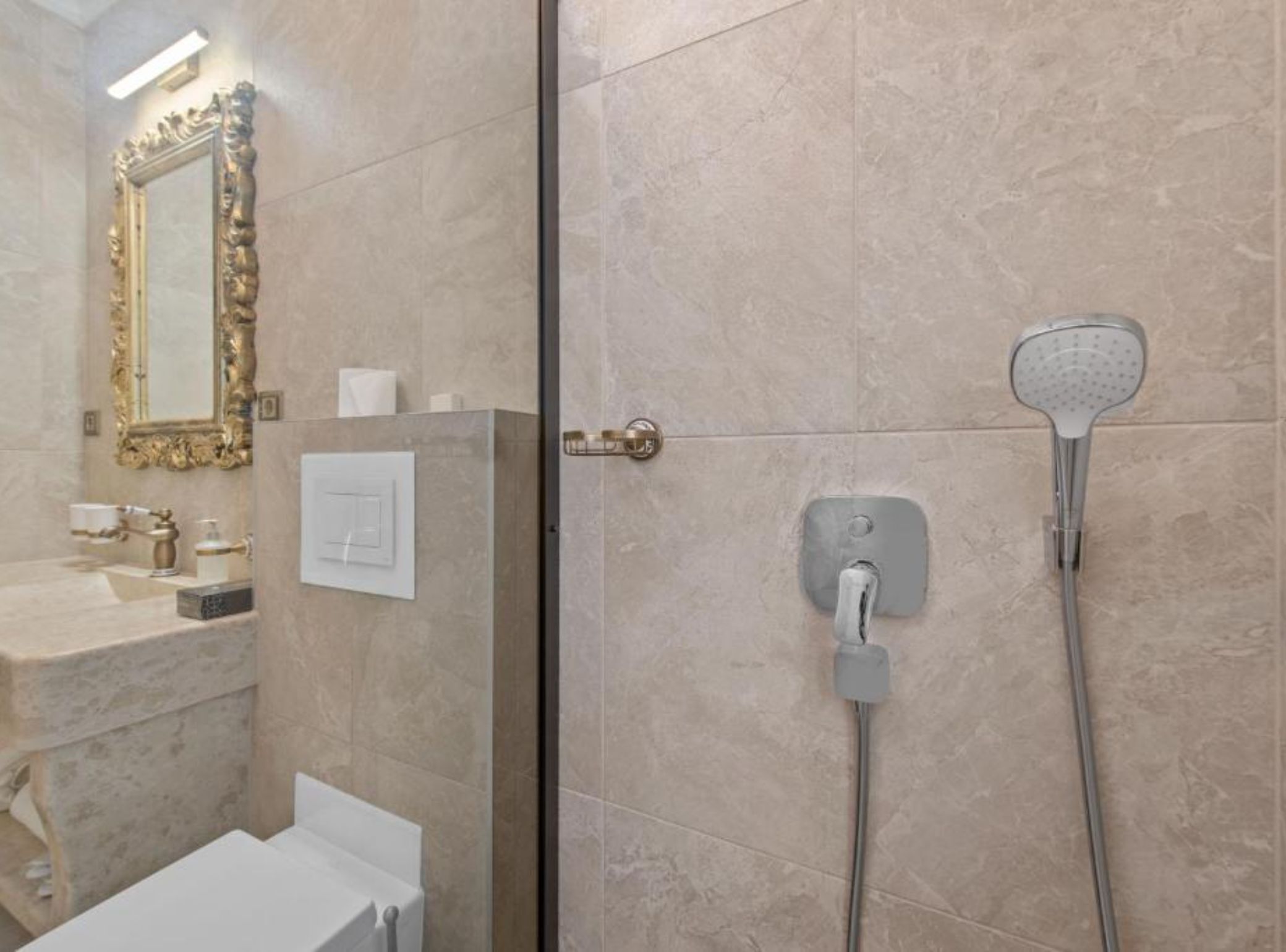A bathroom with a shower, a sink, a mirror, and a toilet.