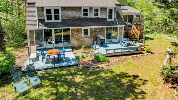 A two-story house with a covered patio, outdoor seating, and a deck. - Private Lake Access, Great for Families! (Orleans)