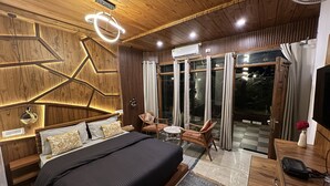 A modern bedroom with a large bed, a desk, and a chair. There is a window with curtains and a view of the outdoors. - House of lights - Solan  (Solan)