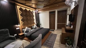 A modern bedroom with a bed, a sofa, a desk, and a TV. - House of lights - Solan  (Solan)