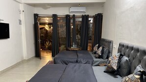 A modern bedroom with a large bed, a sofa, and a dining table. - House of lights - Solan  (Solan)