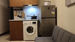 Eine kleine Küche mit Waschmaschine, Herd und Kühlschrank.