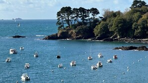A coastal scene with multiple boats on calm waters, surrounded by rocky shores and dense trees. - Rivages Appartement Pleine vue mer Terrasse Privative et Garage (Brest)