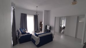 A modern living room with a sofa set, a TV, and a chandelier. - Samos Home by the sea (Samos)