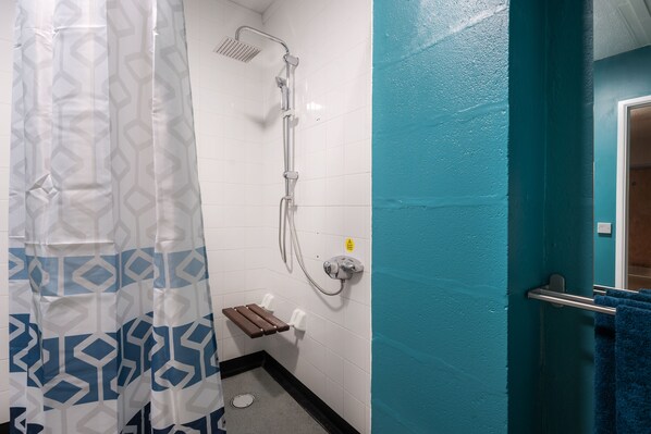 A bathroom with a shower, a towel rack, and a toilet.