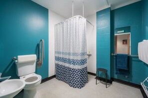 Bathroom features a toilet, bidet, and shower with a geometric-patterned curtain.