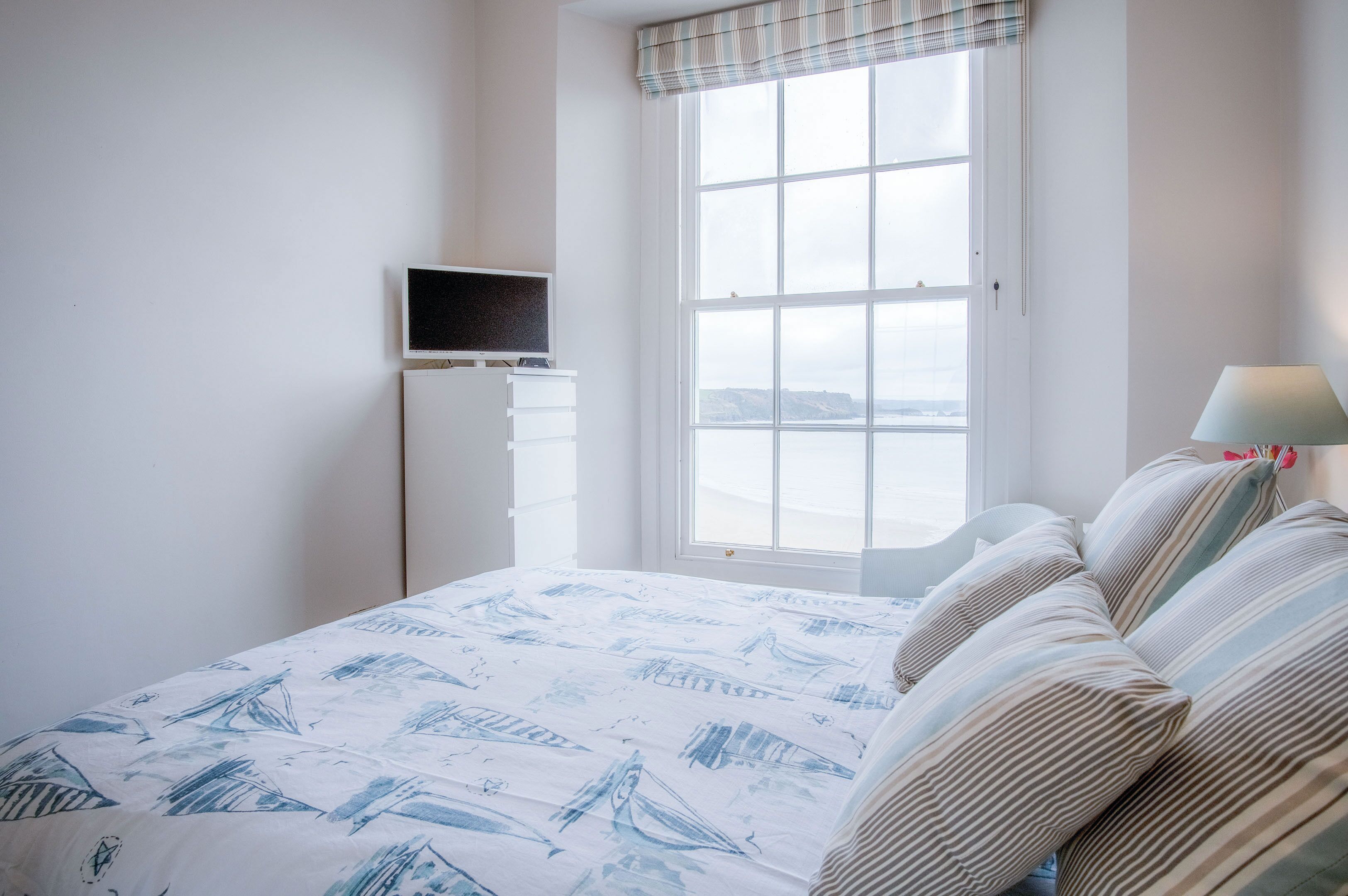Une chambre à coucher avec un lit, une télévision et une fenêtre donnant sur un beau paysage.