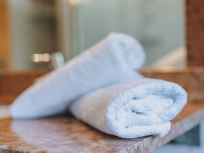 A rolled white towel on a marble countertop in a bathroom. - Appartement Haus Elise by we rent (Zell am See)