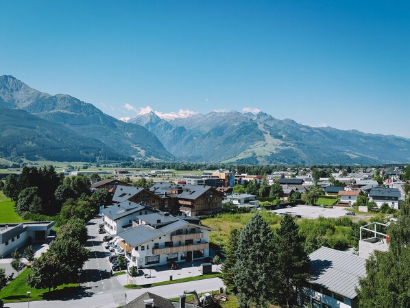 A residential area with modern houses, a parking lot, and a mountain backdrop. - Appartement Haus Elise by we rent (Zell am See)