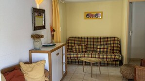Ein gemütliches Wohnzimmer mit einer Couch, einem kleinen Tisch und einer dekorativen Lampe.