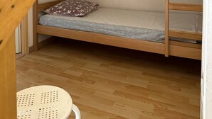 Ein Etagenbett mit Holzbettgestell und einer Matratze auf der Unterliege.