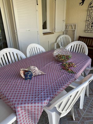 Enjoy a romantic meal for two in this charming outdoor dining area, complete with a beautifully set table and a decorative centerpiece.