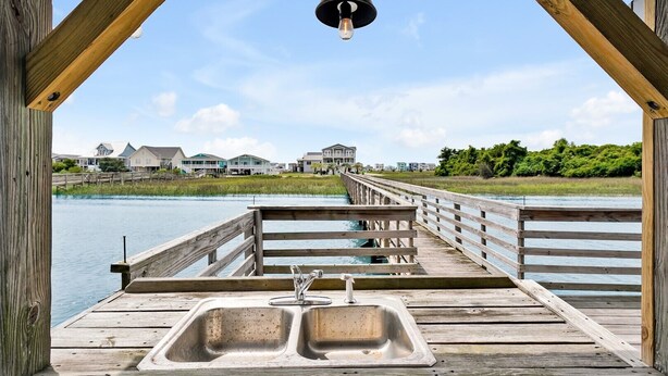 A wooden pier with a metal sink and a hanging light fixture. - Spacious 5BR, 4BA home at Holden Beach with stunning water views. (Holden Beach)