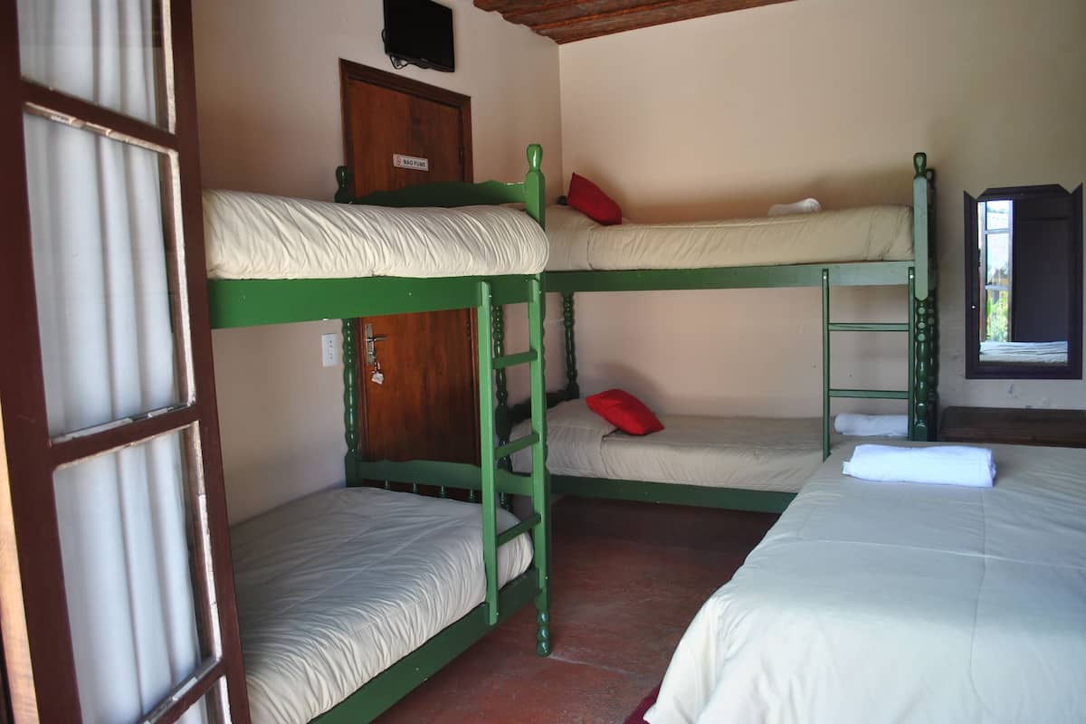 Un dormitorio con literas, una puerta de madera y una ventana.