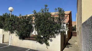 Ein Gebäude mit einem Ziegeldach, einer weißen Wand und einer Straßenlaterne.