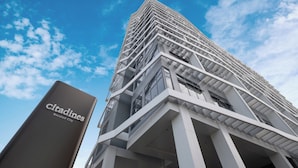 Ein modernes Hochhaus mit einem gut sichtbaren Schild 'Citadines Bacolod City'.
