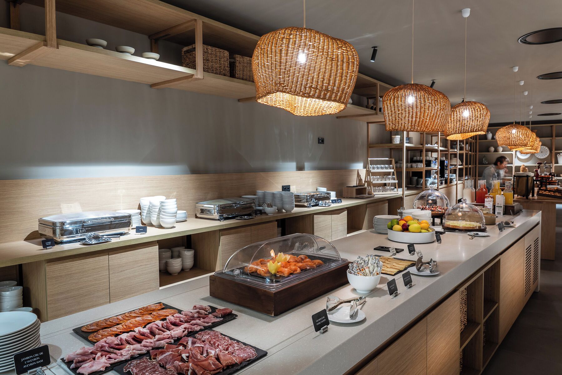 Een buffetopstelling met diverse gerechten, waaronder vleeswaren en fruit, en een koffiehoek.