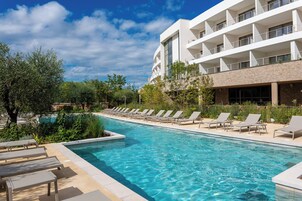 Una piscina al aire libre de temporada, sombrillas