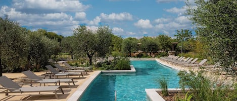 Una piscina al aire libre de temporada, sombrillas