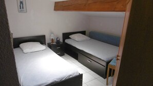 Ein gemütliches Schlafzimmer mit zwei Betten, einem Nachttisch und einem kleinen Tisch.