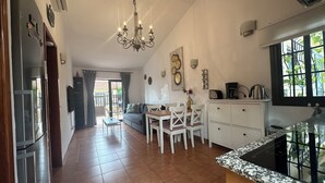 A spacious kitchen with a dining area, a chandelier, and a view of the outdoors.