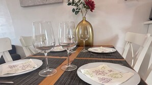 A dining table set with three wine glasses, a gold vase with flowers, and plates with floral napkins.