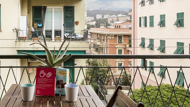 Ein Balkon mit Tisch, Stühlen und einer Speisekarte.