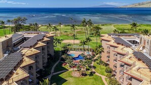 A resort with multiple buildings, a swimming pool, and a view of the ocean.