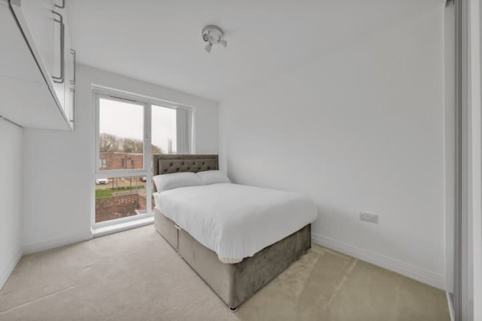 Une chambre à coucher avec un lit, une fenêtre et une vue sur l’extérieur.